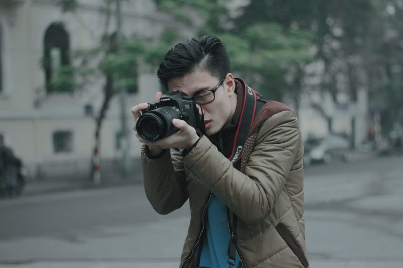 young man taking a picture using a DSLR camera