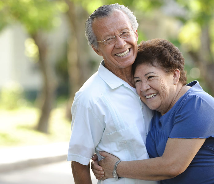 Older couple hugging outdoors